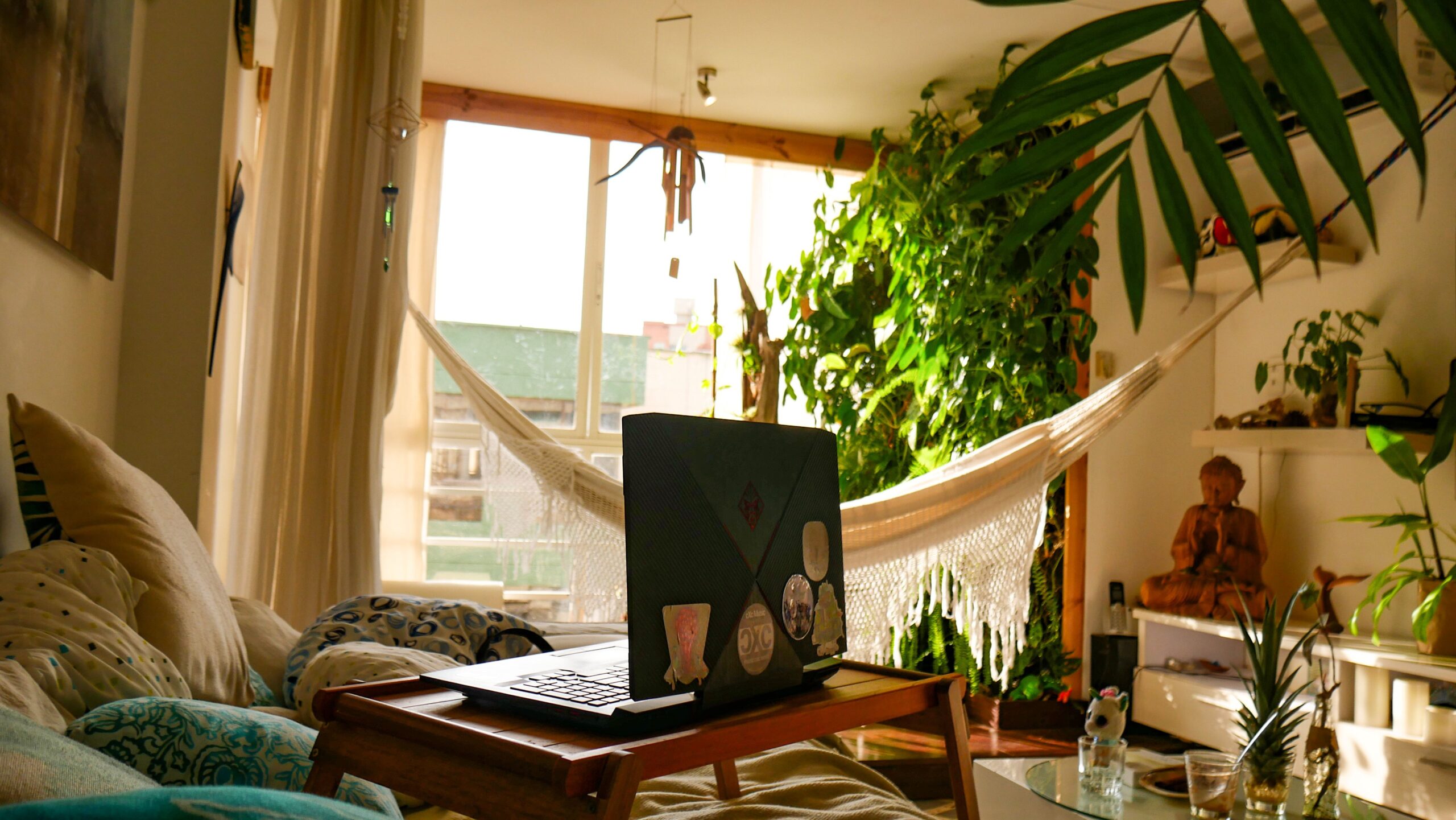 Dreamy boho bedroom with linen bedding, canopy fabric, rattan accents, and filtered sunlight