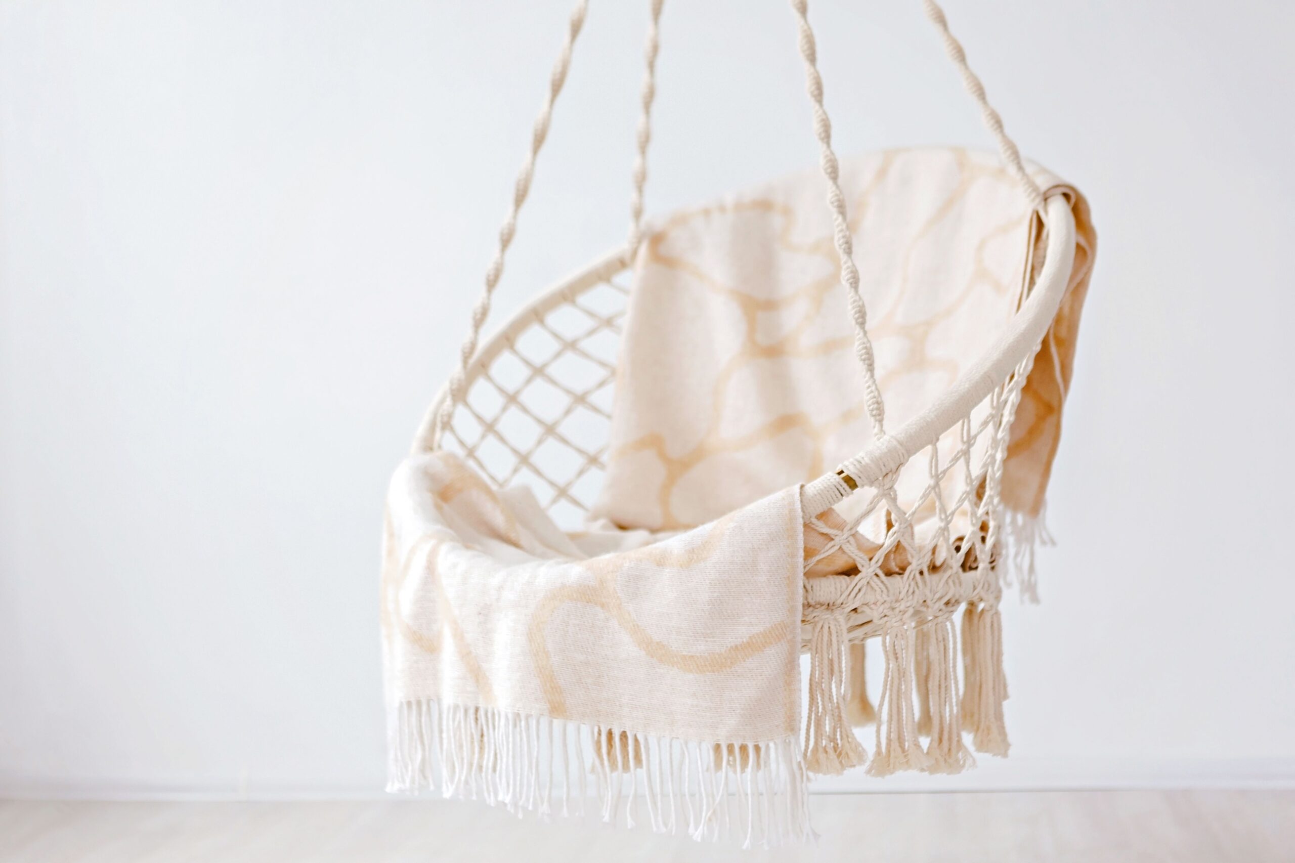 Boho lounge glowing with woven pendant lighting, lamps, lanterns, candles, and plants