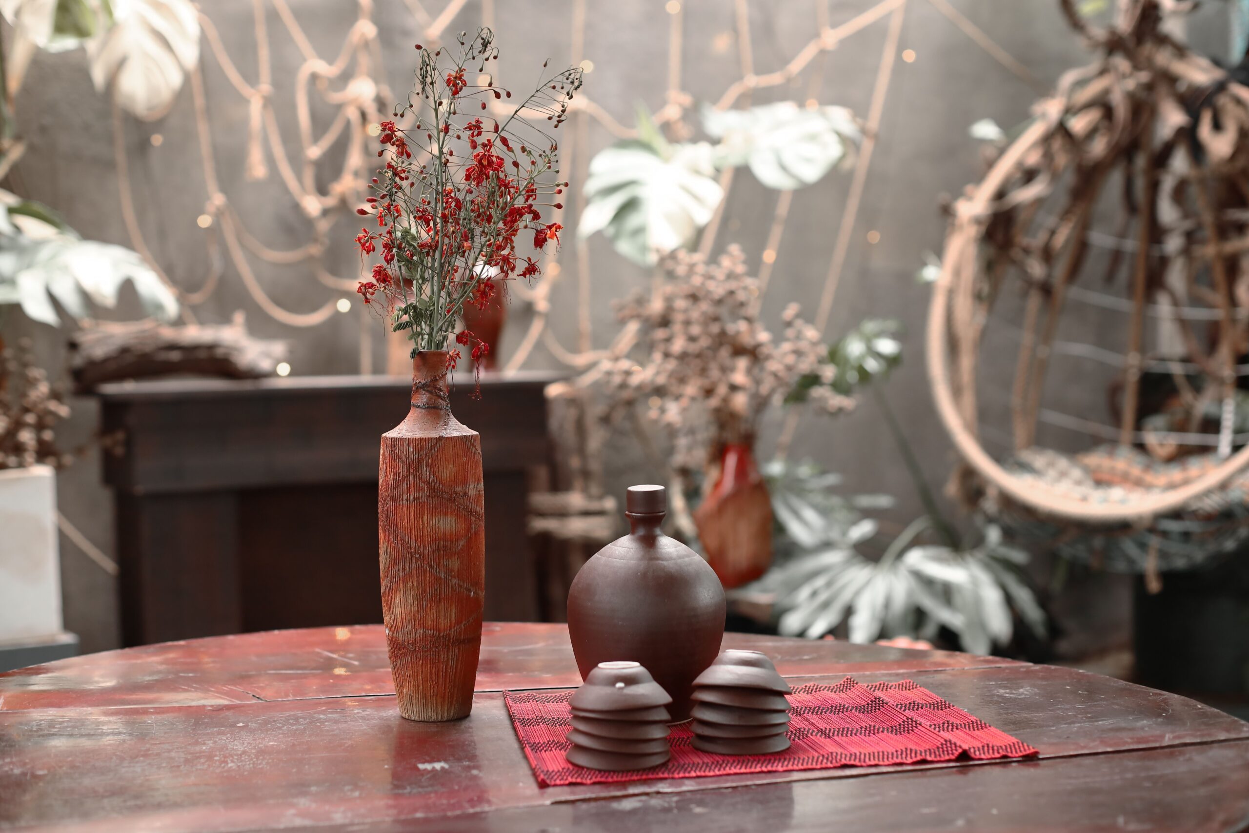 Layered jute and patterned rugs beneath a sofa and round wooden coffee table in a boho room.
