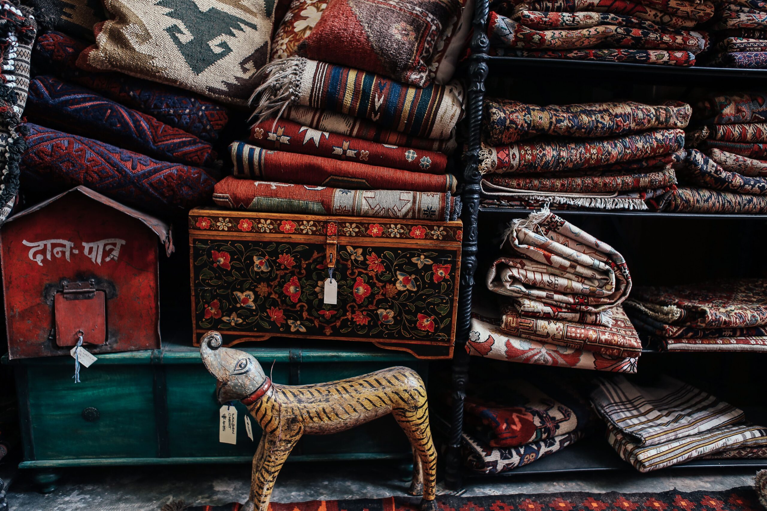 Layered cushions, knitted throw, and patterned rugs in a cozy bohemian seating area