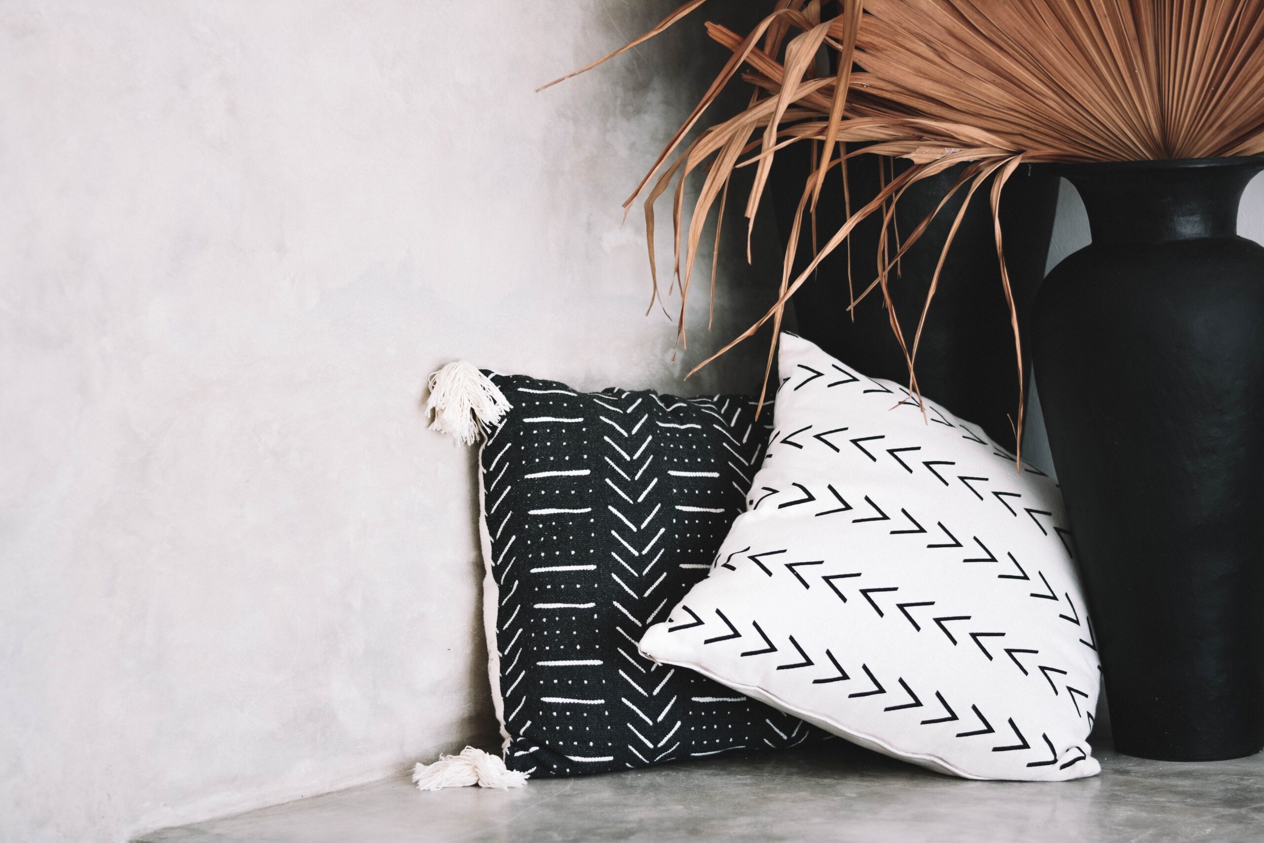 Natural woven, wooden, terracotta, and handmade ceramic decor arranged in a bohemian corner