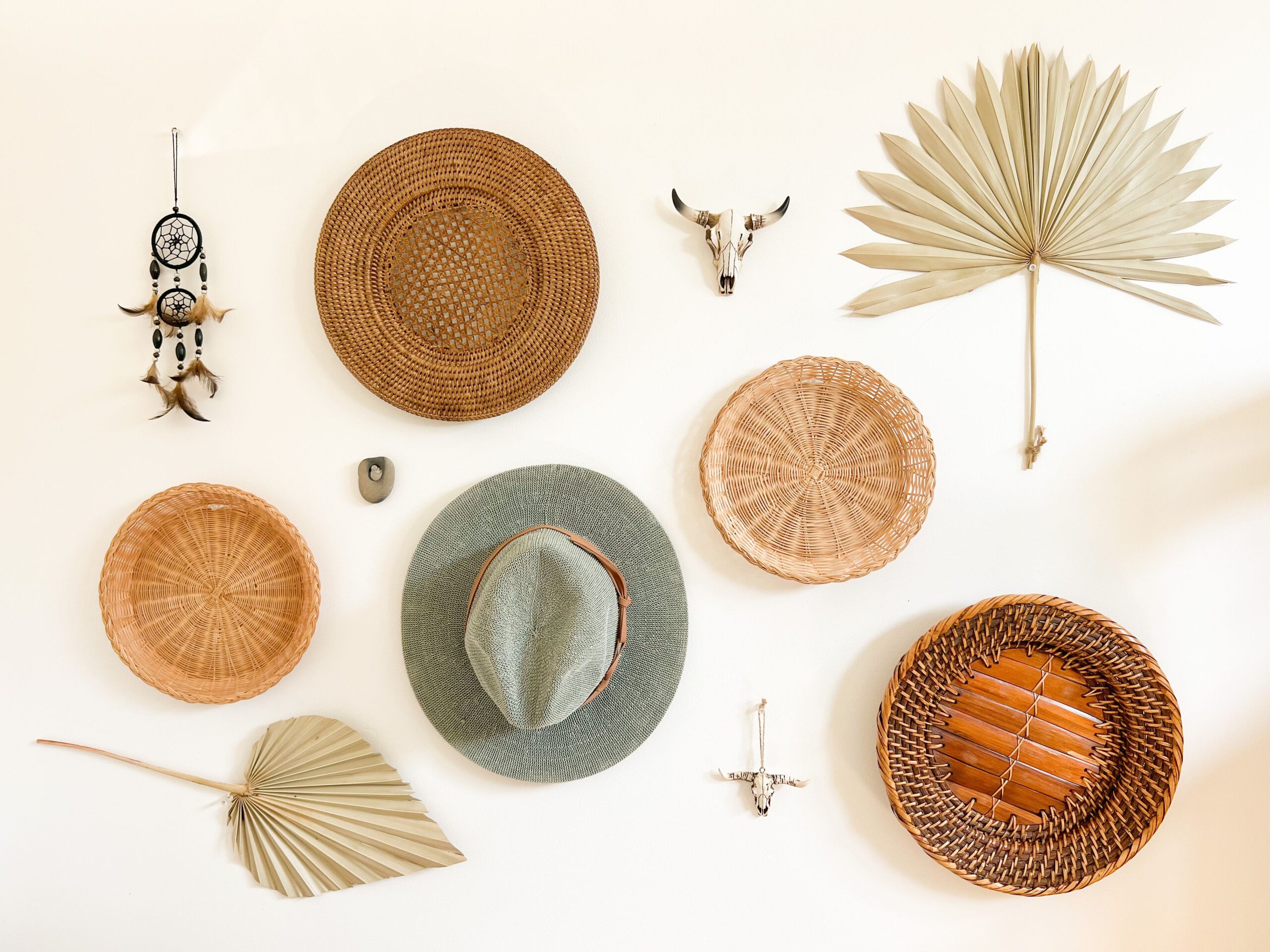 A boho room corner filled with plants, woven planters, ceramic pots, baskets, and natural accents.