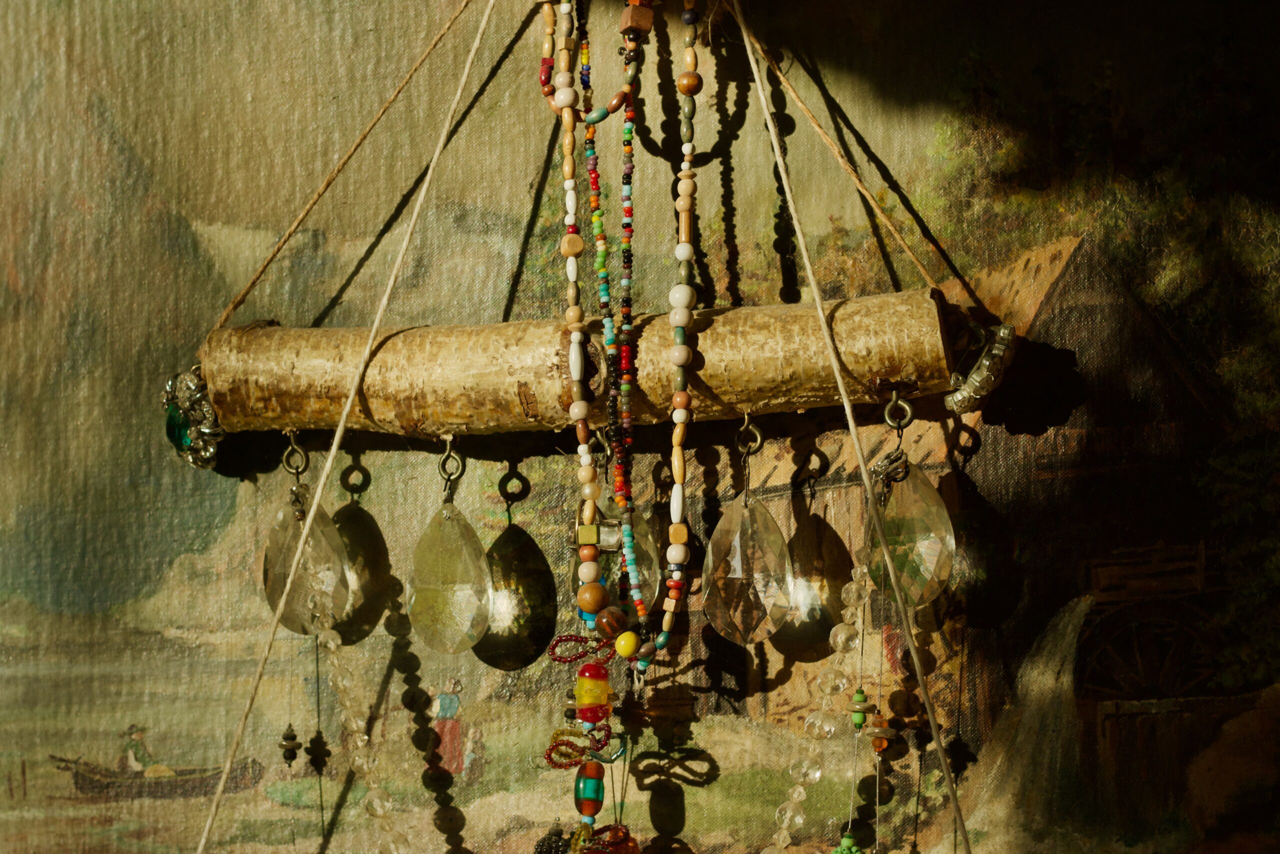 A warmly lit boho room with woven lamps, candles, textured walls, and earthy furnishings.
