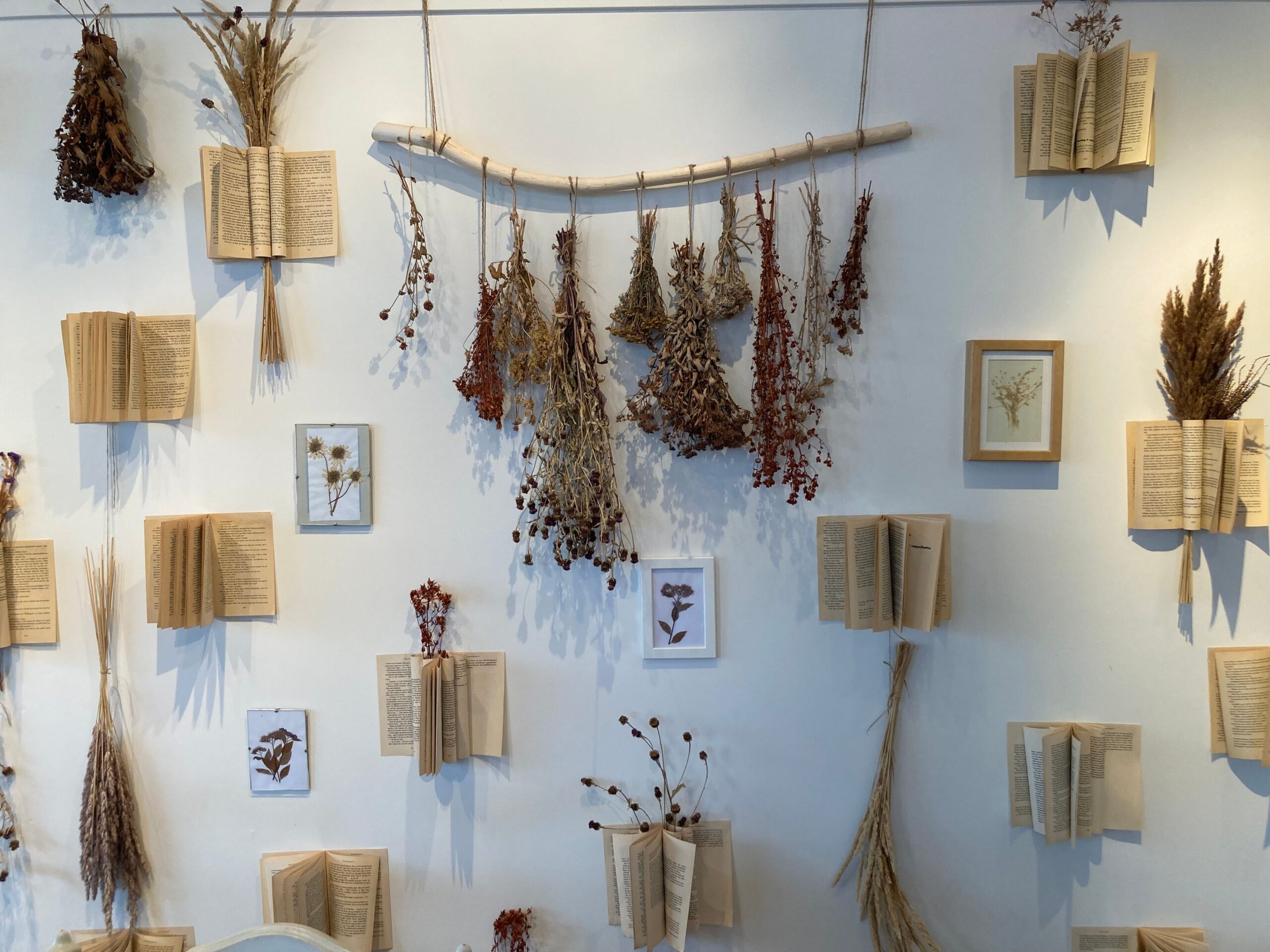 Cozy boho room with woven pendant, lamps, candlelight, earthy textiles, wood furniture and plants