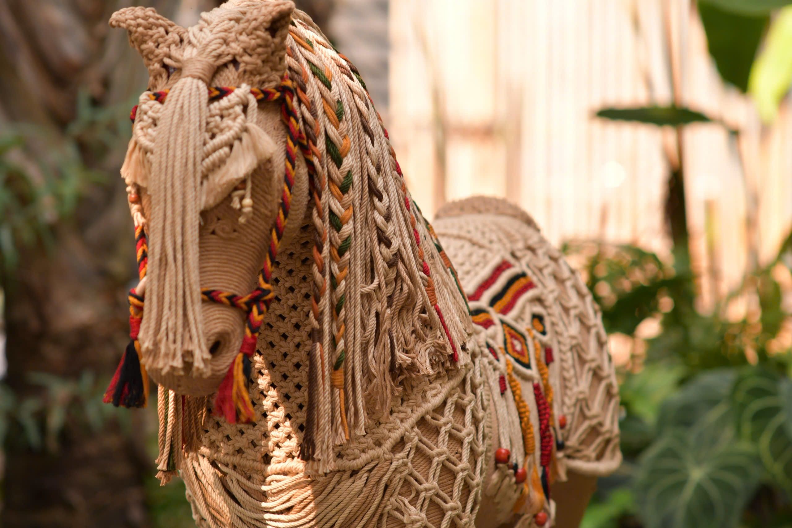 Woven baskets and open shelving organized with blankets, books, ceramics, and a small plant.